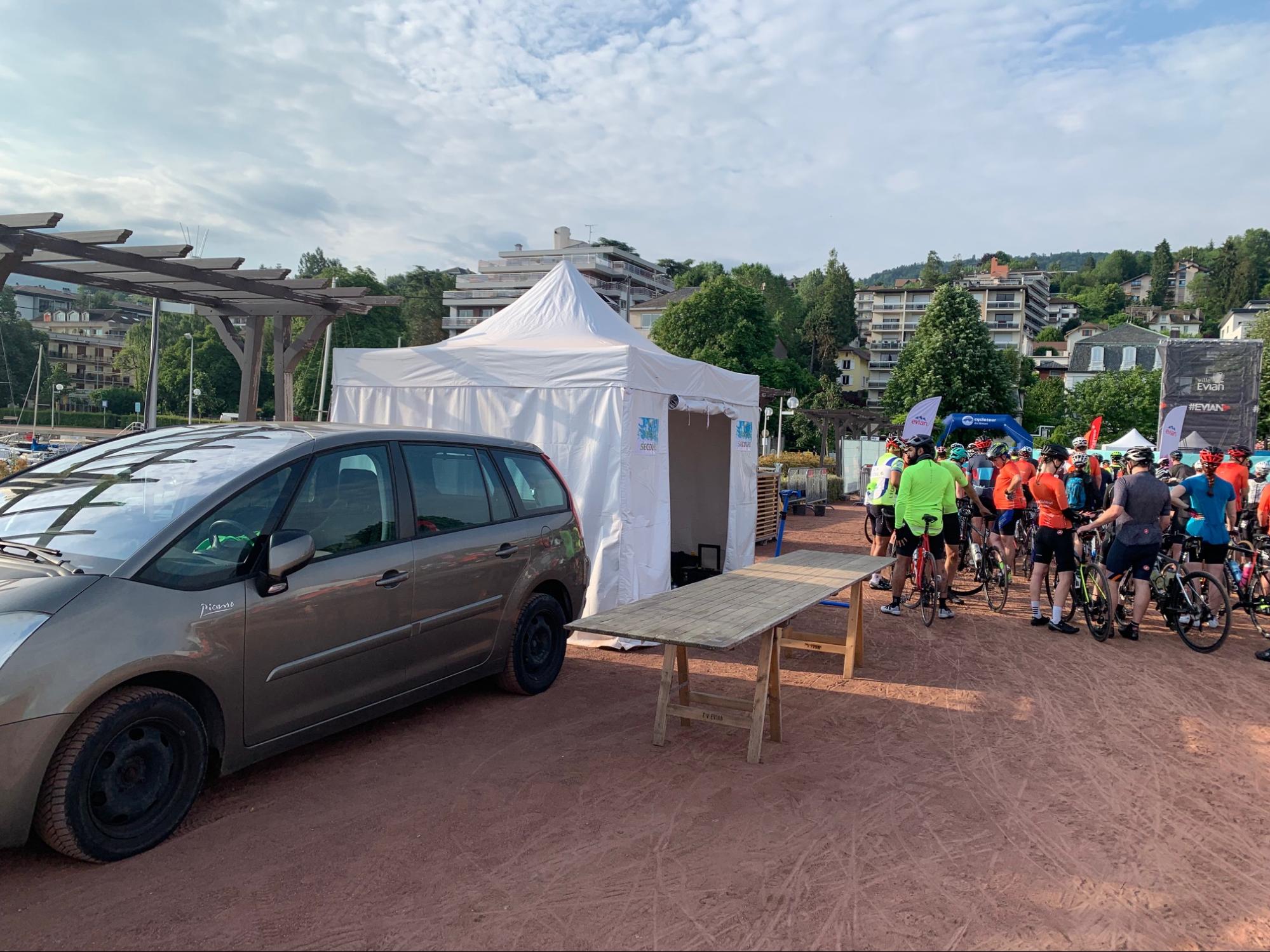 le stand de mécnique de veloval sur Cyclotour du Léman avec en fond un gros groupe de cycliste dans le port d'evian